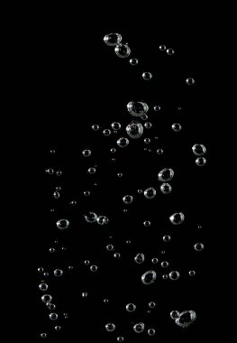 Köpüklü soda ve beyaz oksijen havası, su yüzeyinde kabarcıklar akan temiz su altında, siyah bir zemin üzerinde.