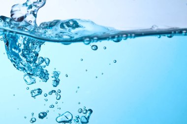 Bardaktan boşanırcasına akan mavi dalgalar ve kabarcıklar doğada su yüzeyine taştı. kopyalama alanı ile