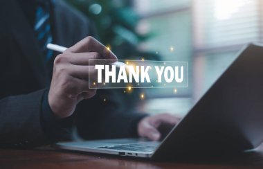 Bir iş adamı, bir dizüstü bilgisayardaki dijital teşekkür mesajıyla etkileşime geçerek memnuniyeti, minnettarlığı, olumlu iletişimi, müşteri ilişkilerini ve profesyonel tanımayı temsil eder..