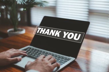 Bir iş adamı, bir dizüstü bilgisayardaki dijital teşekkür mesajıyla etkileşime geçerek memnuniyeti, minnettarlığı, olumlu iletişimi, müşteri ilişkilerini ve profesyonel tanımayı temsil eder..