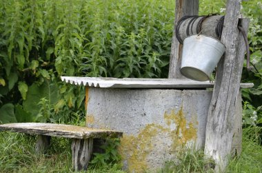  ahşap ile eski bir kuyunun Close-up hangi asmak bir kova ve kupa kirişler