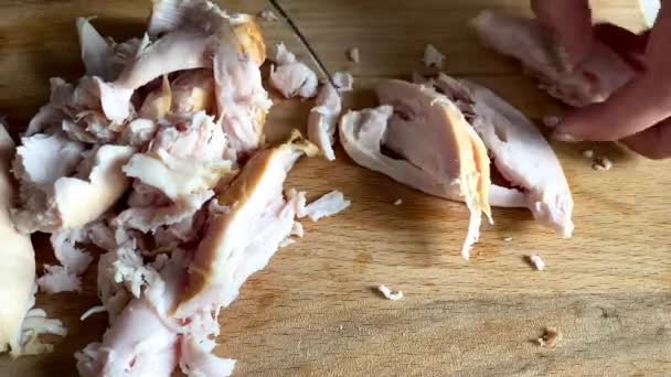 Cooking pizza. hand cuts boiled chicken breast into strips on a wooden board — Stock Video