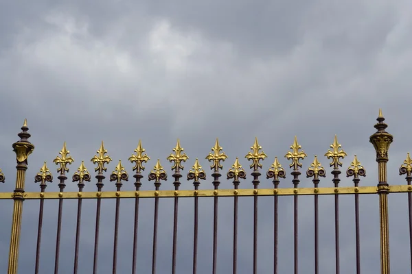 Beautiful ornament on the background of the fence gloomy sky — Stock Photo, Image