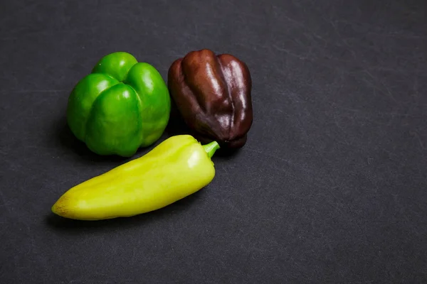 Siyah arkaplanda çok renkli dolma biber.