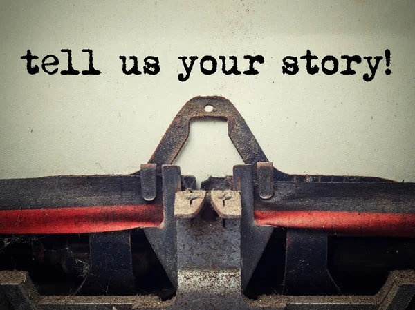 Raccontaci la tua storia testo su vecchia macchina da scrivere coperto di polvere — Foto Stock