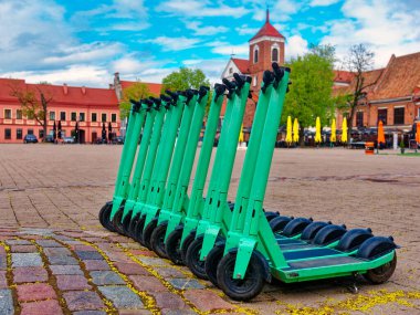 Kaldırımda limansız elektrikli scooterlar. Şehirdeki her gün için elektrikli scooter ekonomik araç