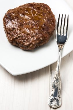 Hamburger beyaz tabakta.