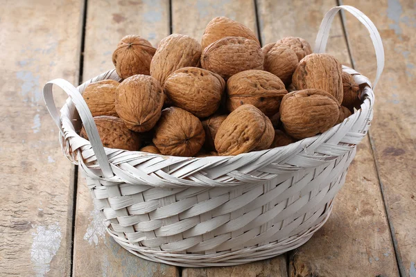 Korb mit Weidenkorb gefüllt mit ganzen Walnüssen — Stockfoto