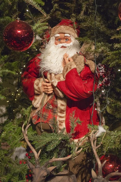 Babbo Natale decorativo sull'albero di Natale con luci accese e renne — Foto Stock