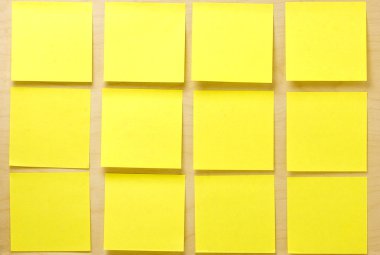 Bir ahşap tahta üzerine yapıştırılmış boş iyi bir şekilde sarı postit notlar