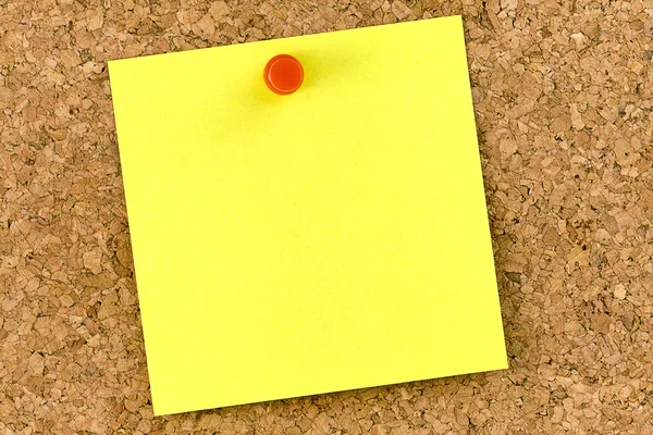 Blank yellow postit affixed on cork board with red thumbtack — Stock Photo, Image