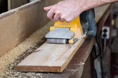 carpenter works with belt sander in carpentry clipart