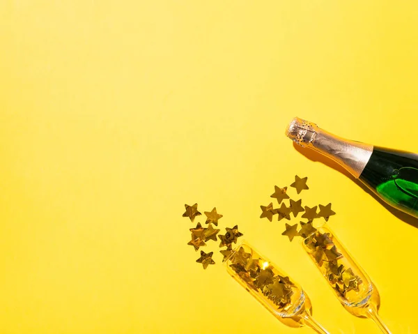 Şampanya Şişesi Altın Yıldızlı Flüt Bardakları Sarı Kağıttan Arka Planda — Stok fotoğraf