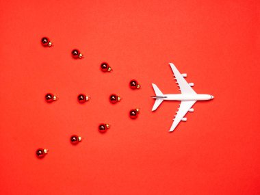 Kırmızı kağıtta uçak ve süsler. Noel ya da yeni yıl festivali konsepti. Düz yatış, üst görünüm.