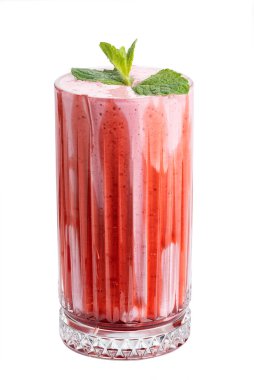 Beyaz arka planda meyveler ve egzotik yapraklarla süslenmiş bir bardakta çilekli milkshake kokteyli.