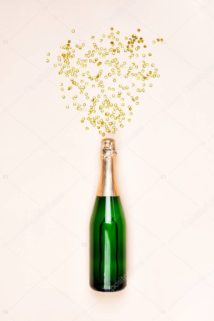 Green bottle of champagne with gold confetti splash