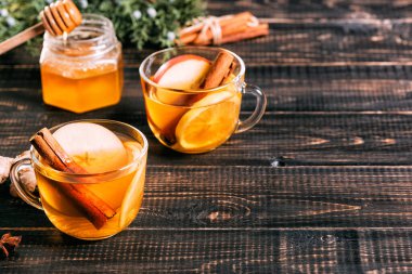 Koyu ahşap masada limonlu bir bardak sıcak zencefil çayı..