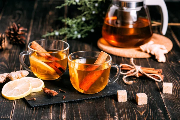 Koyu ahşap masada limonlu bir bardak sıcak zencefil çayı..