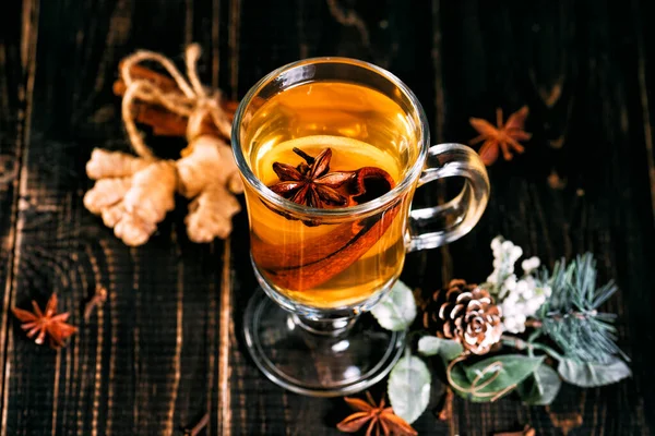 Скляна чашка гарячого імбирного чаю з лимоном на темному дерев'яному столі . — стокове фото