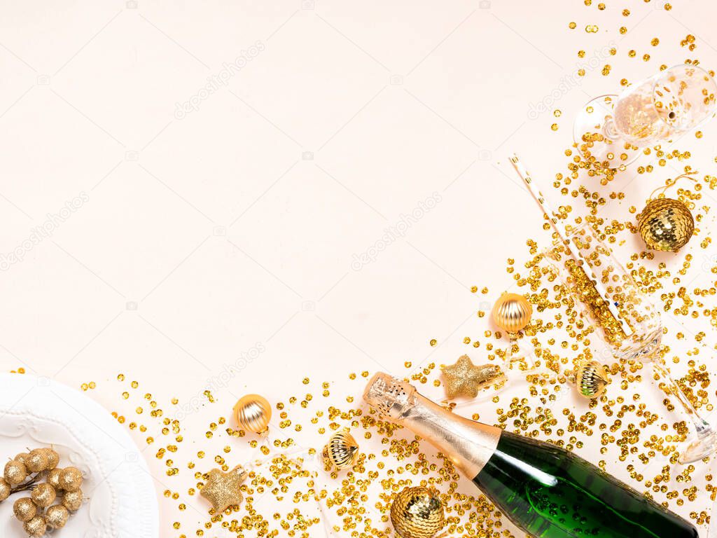 Green bottle of champagne with gold confetti and Christmas ornaments