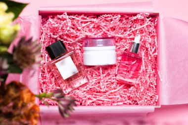 Paramparça pembe kağıtlarla dolu kozmetiklerle dolu bir güzellik kutusu.