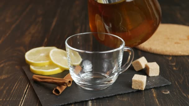 Glazen kopje hete gemberthee met citroen op donkere houten tafel. — Stockvideo