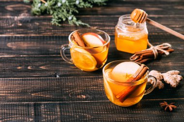 Bir bardak sıcak zencefil çayı, limon ve ballı.