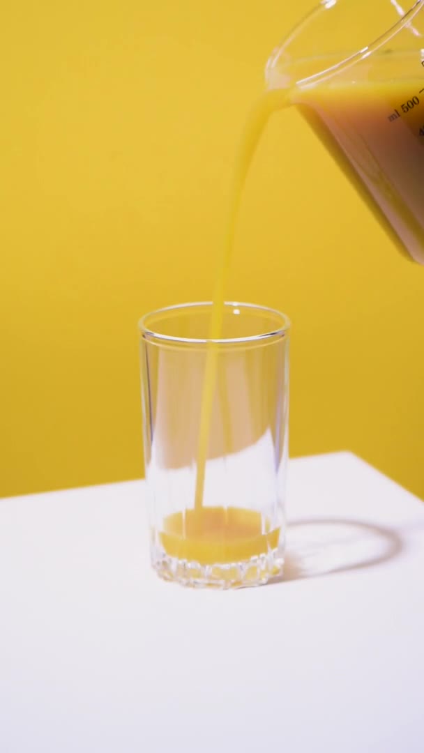Friss mangólevet öntök egy pohárba. Függőleges videó. — Stock videók