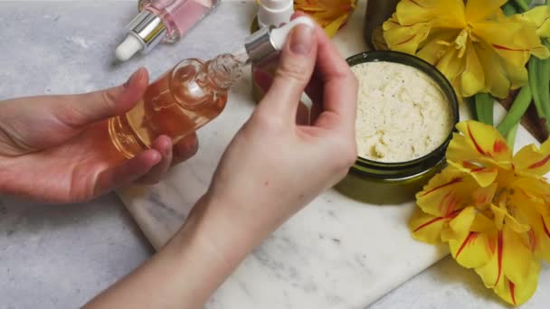 Vrouwelijke handen verzorging, spa concept. Natuurlijke body scrub en bloemen — Stockvideo