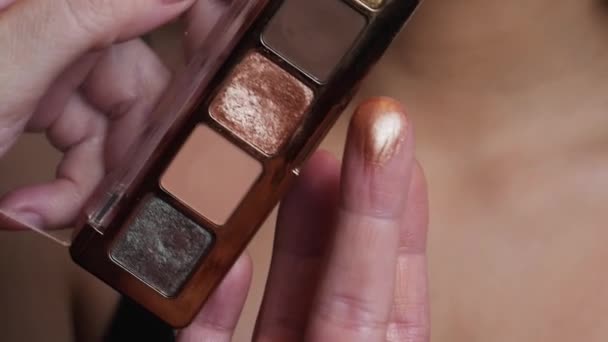 Makeupartisten applicerar bronsskuggor på det kvinnliga ögat med en borste — Stockvideo