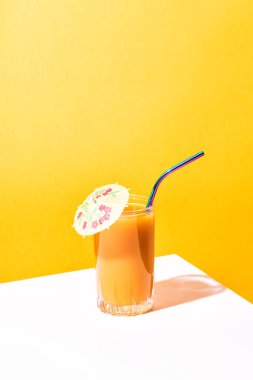 Bir bardak taze mango suyu kokteyli ve palmiye dalları.