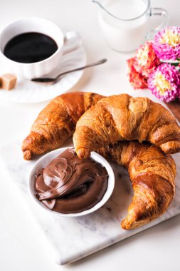 Çikolatalı fındıklı kruvasan ve bir fincan kahve.