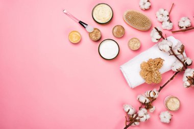 Pembe arka planda cilt ürünleri olan kozmetik kapları