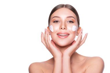 Yüzünde nemlendirici krem olan güzel bir model kadın..