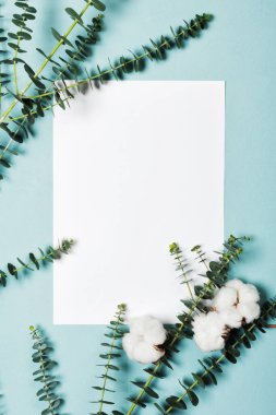 Davetiye kartı, okaliptüs dalları ve pamuk çiçekleriyle birlikte.