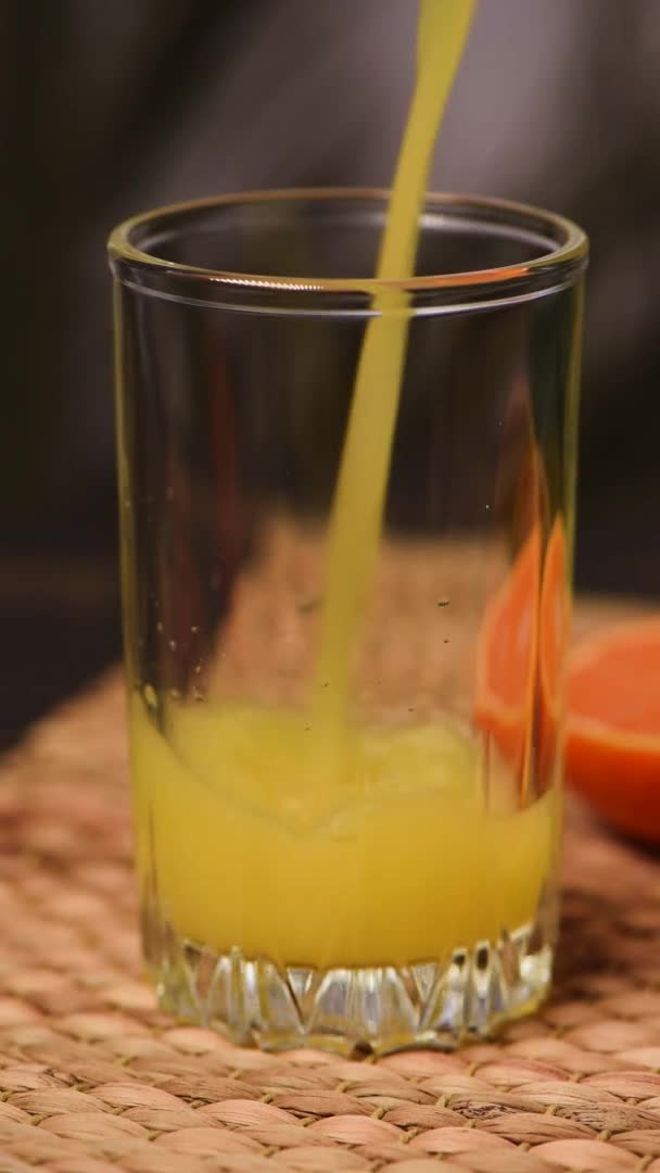 Ρίχνουμε χυμό πορτοκαλιού σε ένα ποτήρι. Φρέσκο καλοκαιρινό ποτό — Αρχείο Βίντεο
