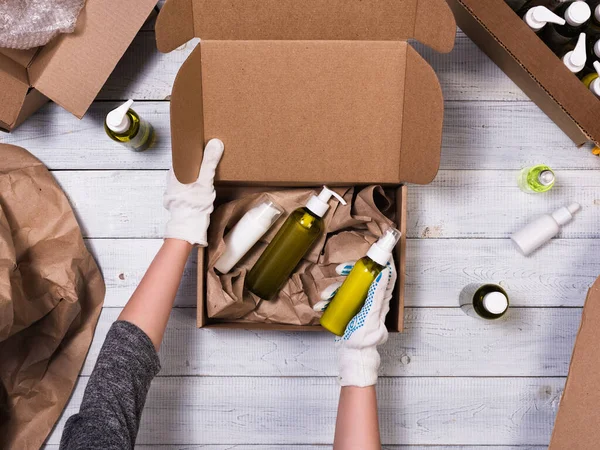 Kartonnen doos met cosmetische flessen op houten ondergrond Rechtenvrije Stockfoto's