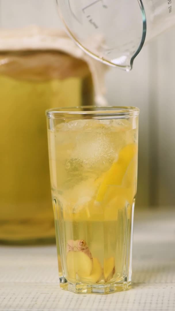 Vierta la bebida de té kombucha casera filtrada en un vaso — Vídeo de stock