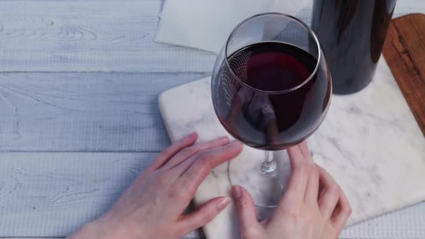 Sklenice červeného vína na mramorovém podnose v restauraci. — Stock video