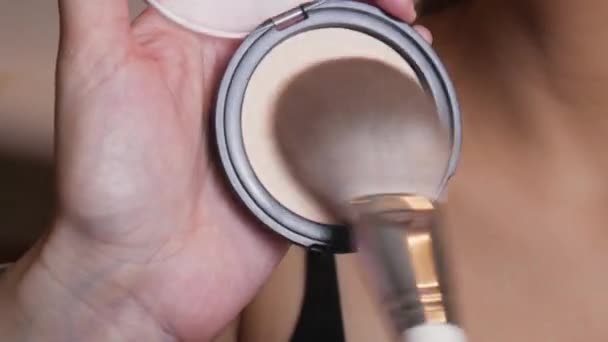 Makeupartisten applicerar en beige puderfoundation på det kvinnliga ansiktet — Stockvideo