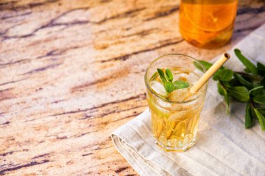 Mermer tepside ve ahşap masada bir bardak narenciye çayı..