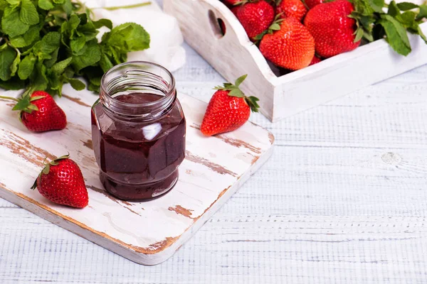 Sklenice jahodové marmelády na dřevěné rustikální desce. — Stock fotografie