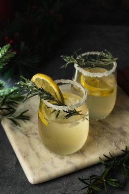 Taş bir tahtaya otlar ve şekerle süslenmiş şenlikli bir narenciye içeceği, menüler ve reklamlar için zarif bir kış kompozisyonu.