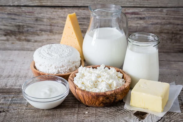 Auswahl an Milchprodukten auf rustikalem Holzspeck — Stockfoto