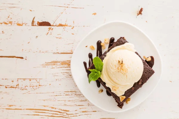 Шоколадне брауні з ванільним морозивом, горіхами та м'ятою — стокове фото