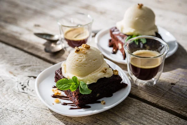 Шоколадне брауні з ванільним морозивом, горіхами та м'ятою — стокове фото