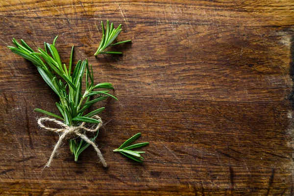 Rosmarinstrauß auf rustikalem Holztisch, Kopierraum — Stockfoto