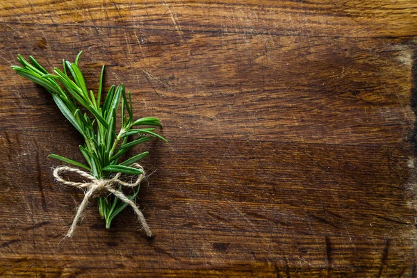 Rosemary parta na rustikální dřevěný stůl, kopie prostor — Stock fotografie