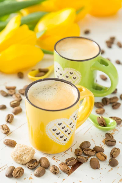 Café en tasses vertes et jaunes, tulipes — Photo