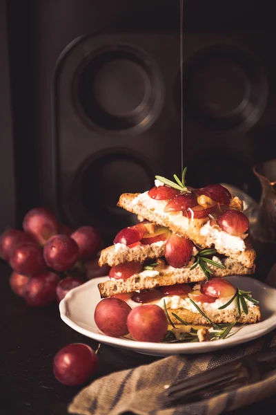 Tostadas con queso de cabra, uvas, frutos secos y miel —  Fotos de Stock